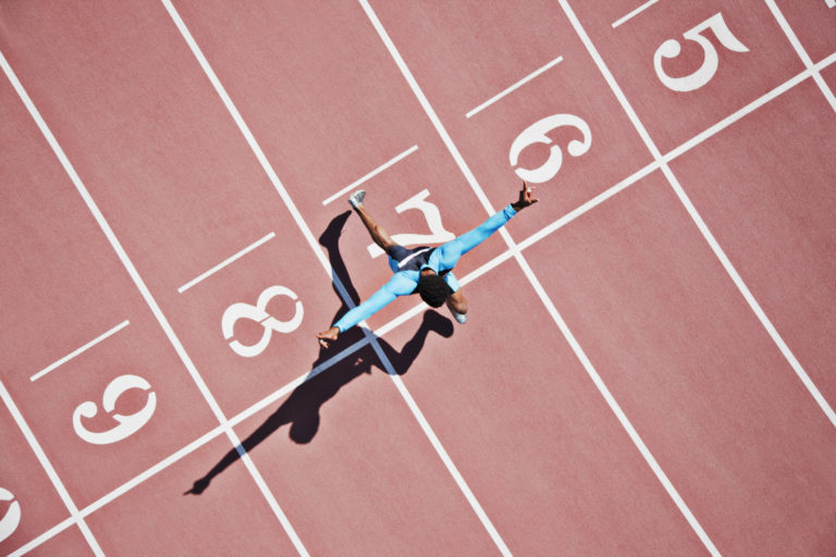 runner crossing the finish line on a track representing accelerated pace of change for employees