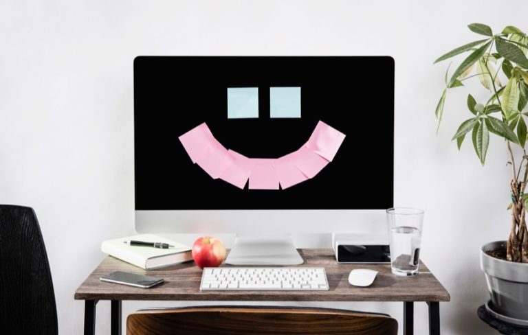 desktop computer with sticky notes in shape of a smiley face