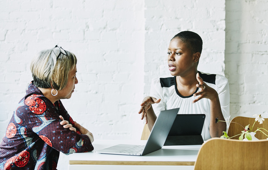 young black woman talking to older white woman representing today's multigenerational workforce