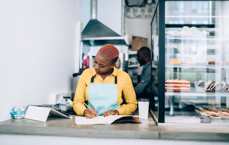 Woman doing book keeping for a small business bakery